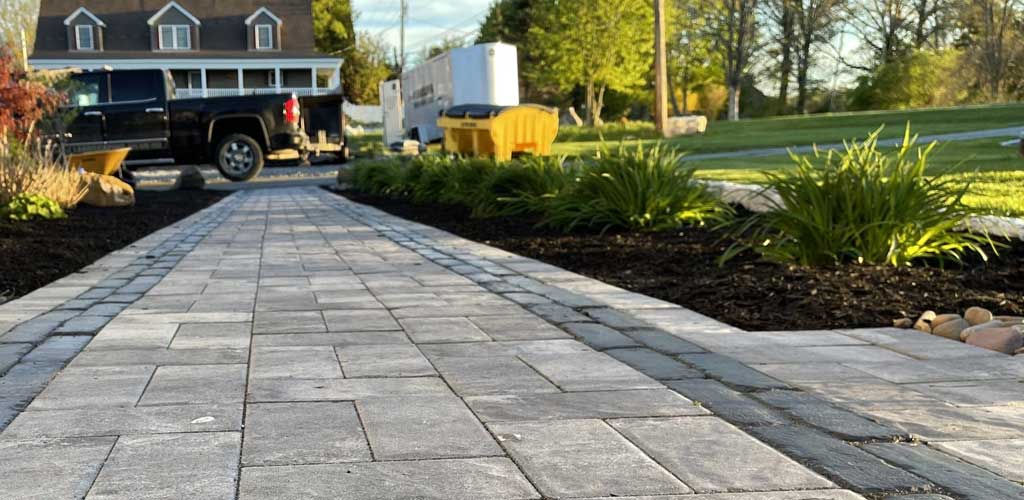 Paving stone walkway with shrubs.