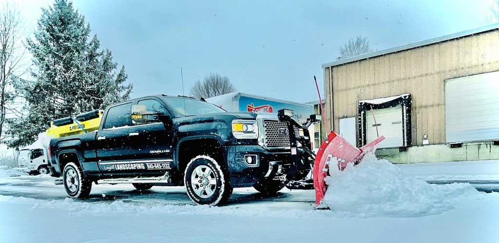 Truck snow plowing commercial parking lot