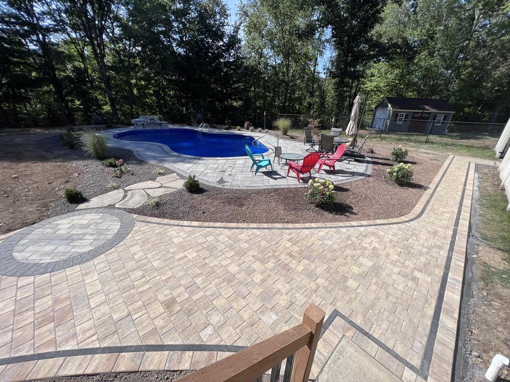 Inground fiberglass pool with stone patio