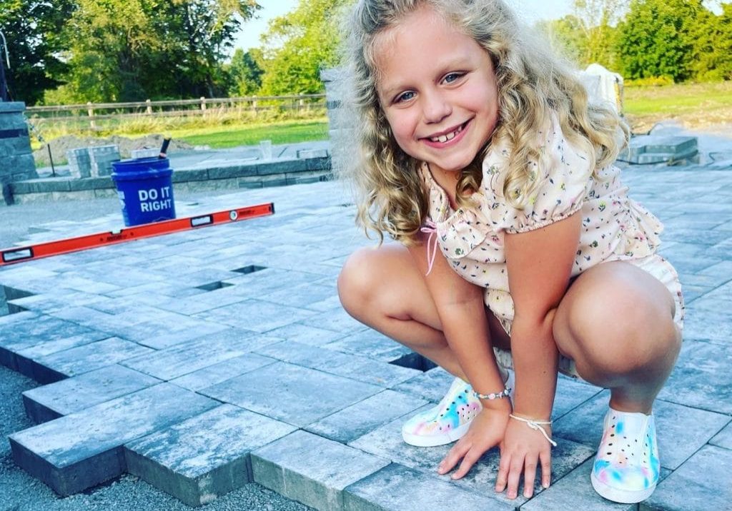 Child on partially finished hardscape patio.