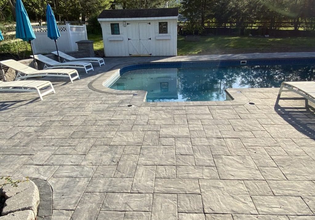 Inground pool with concrete paver hardscape