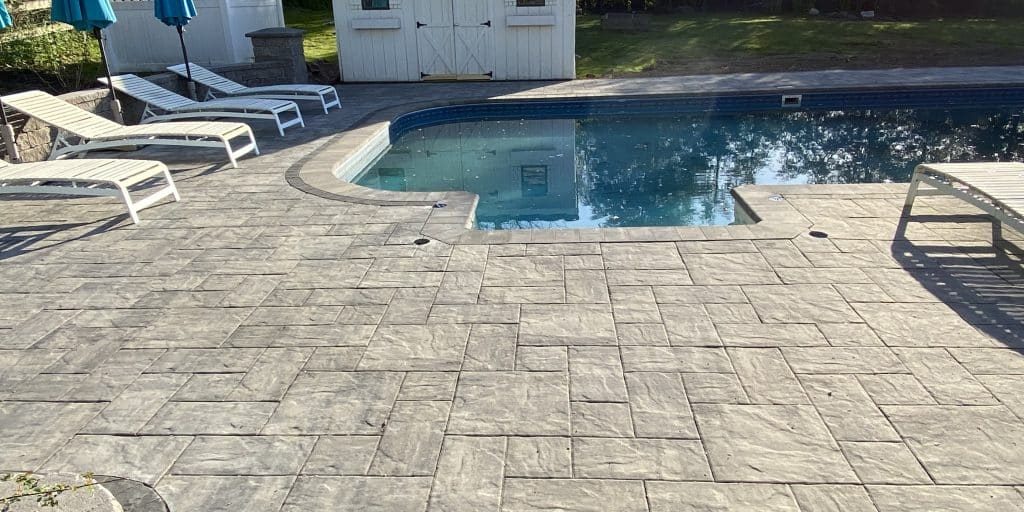 Inground pool with concrete paver hardscape